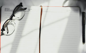 eyeglasses and notebook with pen