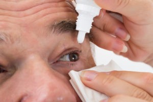 man taking eye drops at Brooks Eye Associates